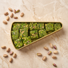 Koçak pistachio ezme cubes in an elegant gold triangle tin. 100% Antep pistachios, rich flavor. Perfect Turkish gift, 150g, made in Türkiye.
