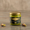 Koçak Pistachio Spread 200g glass jar with gold lid surrounded by fresh Antep pistachios – natural Turkish pistachio butter