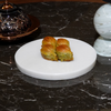 Three pastries on a white marble plate with a dark marble background